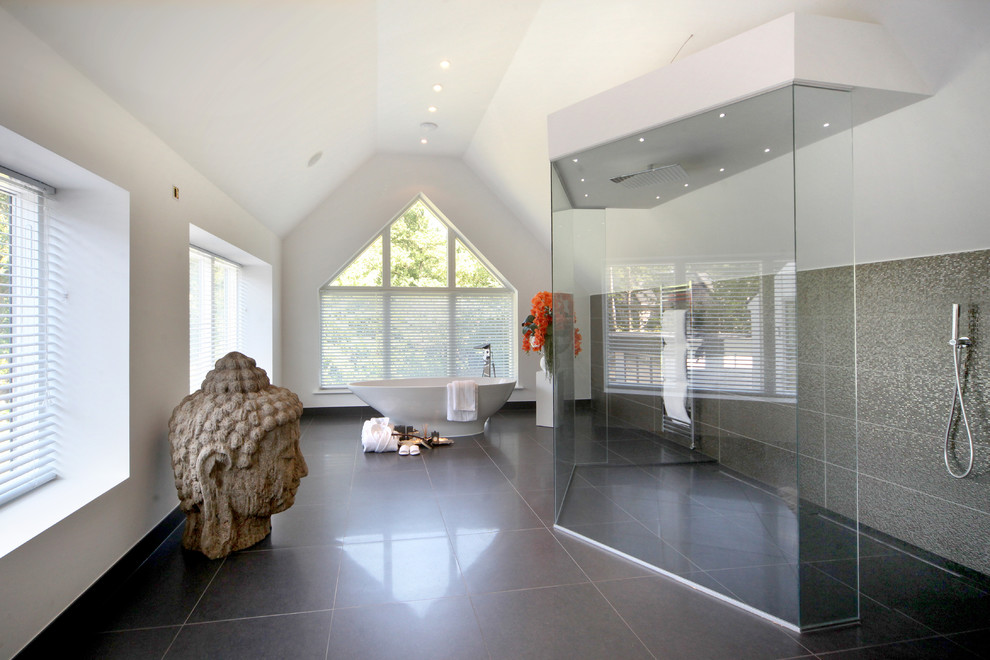 Diseño de cuarto de baño actual grande con bañera exenta, paredes blancas y suelo negro