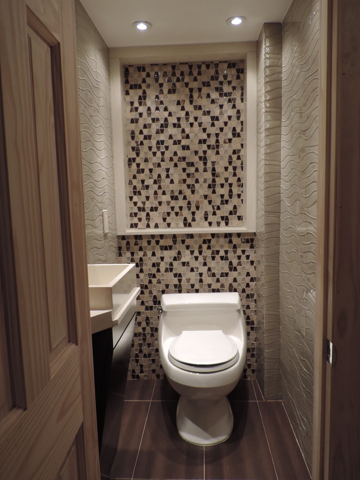 Foto di una piccola stanza da bagno minimalista con lavabo a bacinella, ante lisce, ante in legno bruno, top in quarzo composito, piastrelle beige, piastrelle di vetro, pavimento in gres porcellanato, WC monopezzo e pareti grigie