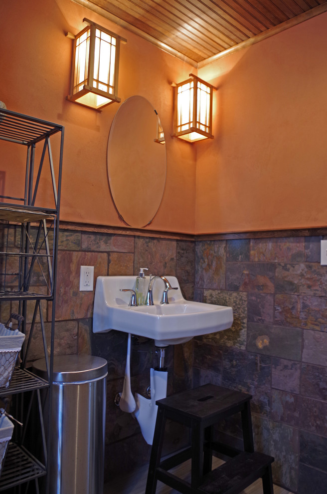 Cette image montre une petite salle de bain craftsman avec un carrelage multicolore, un carrelage de pierre, un mur orange et un sol en linoléum.