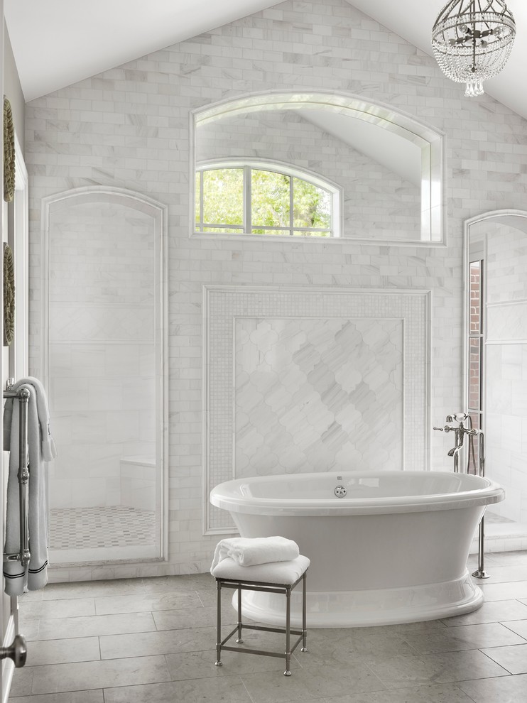 Klassisk inredning av ett stort badrum, med ett fristående badkar, vit kakel och med dusch som är öppen