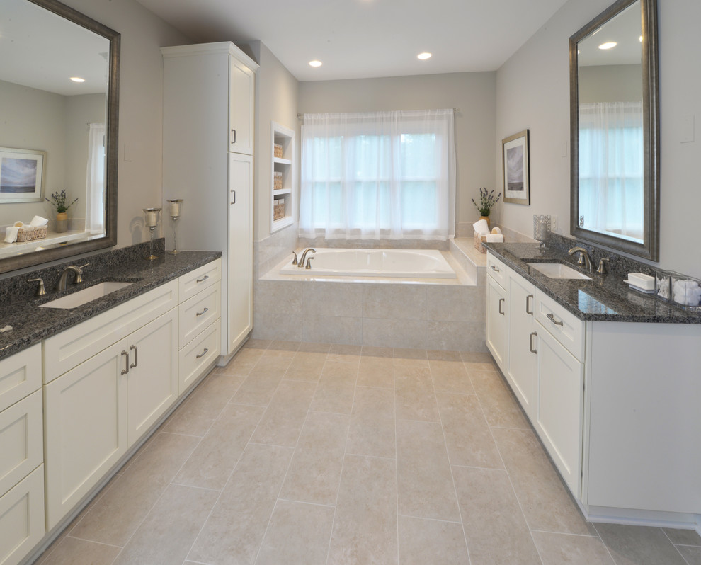 Inredning av ett klassiskt stort grå grått en-suite badrum, med luckor med infälld panel, vita skåp, ett badkar i en alkov, beige kakel, porslinskakel, grå väggar, klinkergolv i porslin, ett undermonterad handfat, granitbänkskiva och beiget golv
