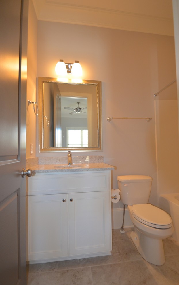 Exempel på ett mellanstort klassiskt badrum, med luckor med infälld panel, vita skåp, ett undermonterat badkar, en dusch i en alkov, en toalettstol med separat cisternkåpa, beige väggar, klinkergolv i keramik, ett undermonterad handfat, granitbänkskiva, beiget golv och dusch med duschdraperi