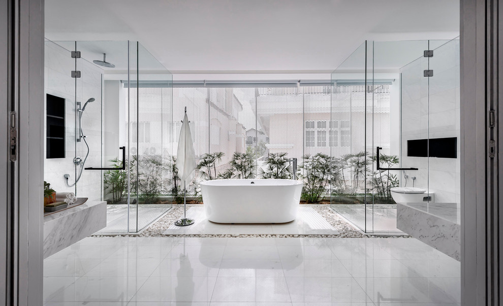 Modern inredning av ett badrum, med ett fristående badkar, en kantlös dusch, en vägghängd toalettstol och vita väggar