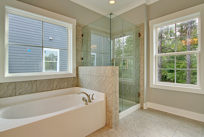 Mid-sized transitional master gray tile, white tile and porcelain tile porcelain tile and beige floor bathroom photo in Charleston with recessed-panel cabinets, white cabinets, gray walls, an undermount sink, granite countertops and a hinged shower door