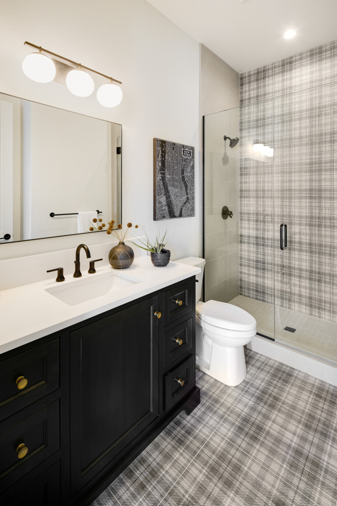 Diseño de cuarto de baño tradicional con armarios con paneles empotrados, puertas de armario negras, ducha empotrada, baldosas y/o azulejos grises, paredes blancas, lavabo bajoencimera, suelo gris y encimeras blancas