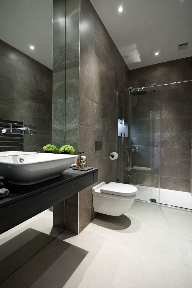Modernes Badezimmer mit dunklen Holzschränken, bodengleicher Dusche, Wandtoilette, braunen Fliesen, Porzellanfliesen, Porzellan-Bodenfliesen und Aufsatzwaschbecken in London