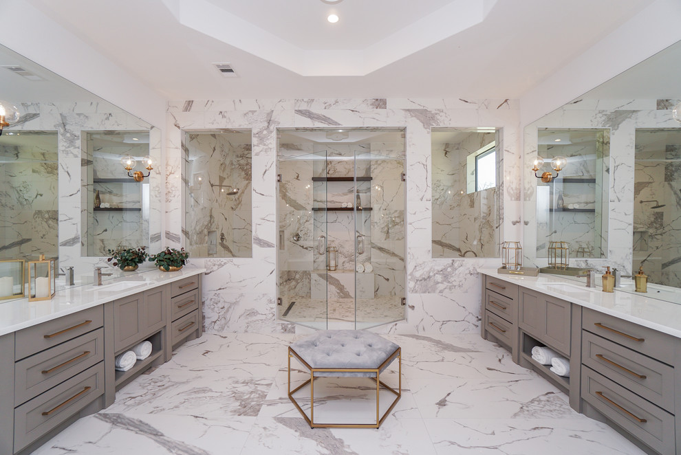 На фото: большая главная ванная комната в стиле неоклассика (современная классика) с фасадами в стиле шейкер, серыми фасадами, белой плиткой, керамогранитной плиткой, стеклянной столешницей, душем с распашными дверями, белой столешницей и врезной раковиной с
