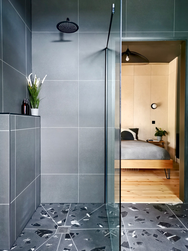 Photo of a medium sized scandi ensuite bathroom in Other with medium wood cabinets, a freestanding bath, a walk-in shower, a wall mounted toilet, grey tiles, porcelain tiles, grey walls, porcelain flooring, a console sink, wooden worktops, grey floors, an open shower, a wall niche, double sinks and a freestanding vanity unit.