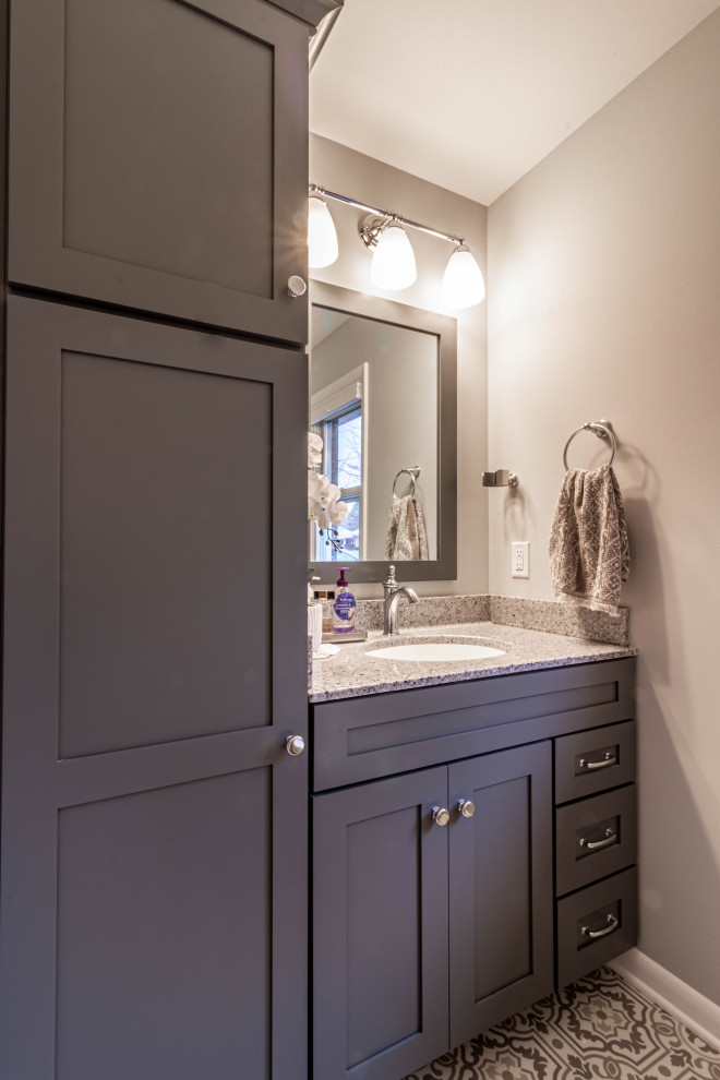 Inspiration for a medium sized traditional ensuite bathroom in Other with shaker cabinets, grey cabinets, an alcove shower, a two-piece toilet, grey walls, vinyl flooring, an integrated sink, solid surface worktops, grey floors, a hinged door, grey worktops, a single sink and a built in vanity unit.