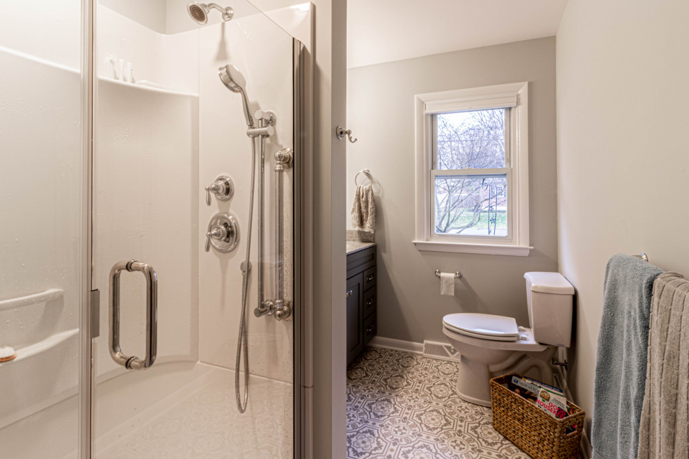 Klassisk inredning av ett mellanstort grå grått en-suite badrum, med skåp i shakerstil, grå skåp, en dusch i en alkov, en toalettstol med separat cisternkåpa, grå väggar, vinylgolv, ett integrerad handfat, bänkskiva i akrylsten, grått golv och dusch med gångjärnsdörr