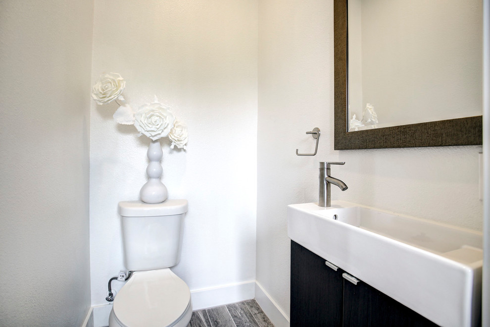 Esempio di una piccola stanza da bagno con doccia chic con ante lisce, ante nere, WC a due pezzi, pareti bianche, pavimento in gres porcellanato, lavabo integrato e pavimento grigio