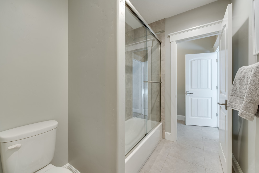 Inspiration for a medium sized classic shower room bathroom in Salt Lake City with recessed-panel cabinets, grey cabinets, an alcove shower, a two-piece toilet, beige tiles, brown tiles, grey tiles, matchstick tiles, grey walls, medium hardwood flooring, a submerged sink, quartz worktops, brown floors and a sliding door.
