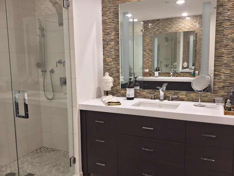 Inspiration for a mid-sized industrial 3/4 beige tile, brown tile and matchstick tile pebble tile floor and gray floor alcove shower remodel in Tampa with flat-panel cabinets, dark wood cabinets, beige walls, an undermount sink, solid surface countertops and a hinged shower door