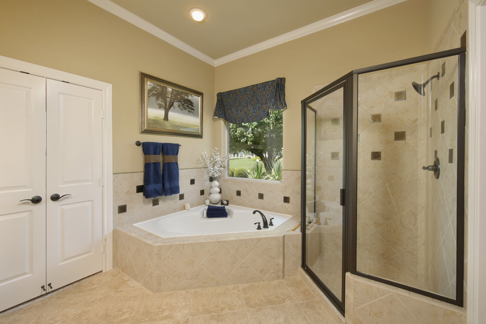Inspiration for a mid-sized timeless master beige tile and porcelain tile porcelain tile and beige floor corner shower remodel in Houston with a two-piece toilet, beige walls and a hinged shower door