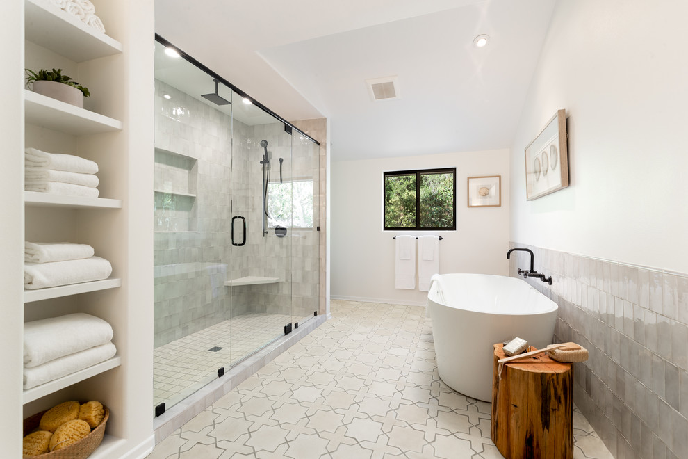 Example of a large beach style master gray tile and ceramic tile cement tile floor and white floor bathroom design in Santa Barbara with flat-panel cabinets, medium tone wood cabinets, a two-piece toilet, white walls, a drop-in sink, quartzite countertops, a hinged shower door and beige countertops
