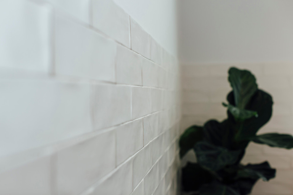 Imagen de cuarto de baño principal actual de tamaño medio con bañera exenta, baldosas y/o azulejos blancos, baldosas y/o azulejos de cemento, paredes blancas y suelo de pizarra