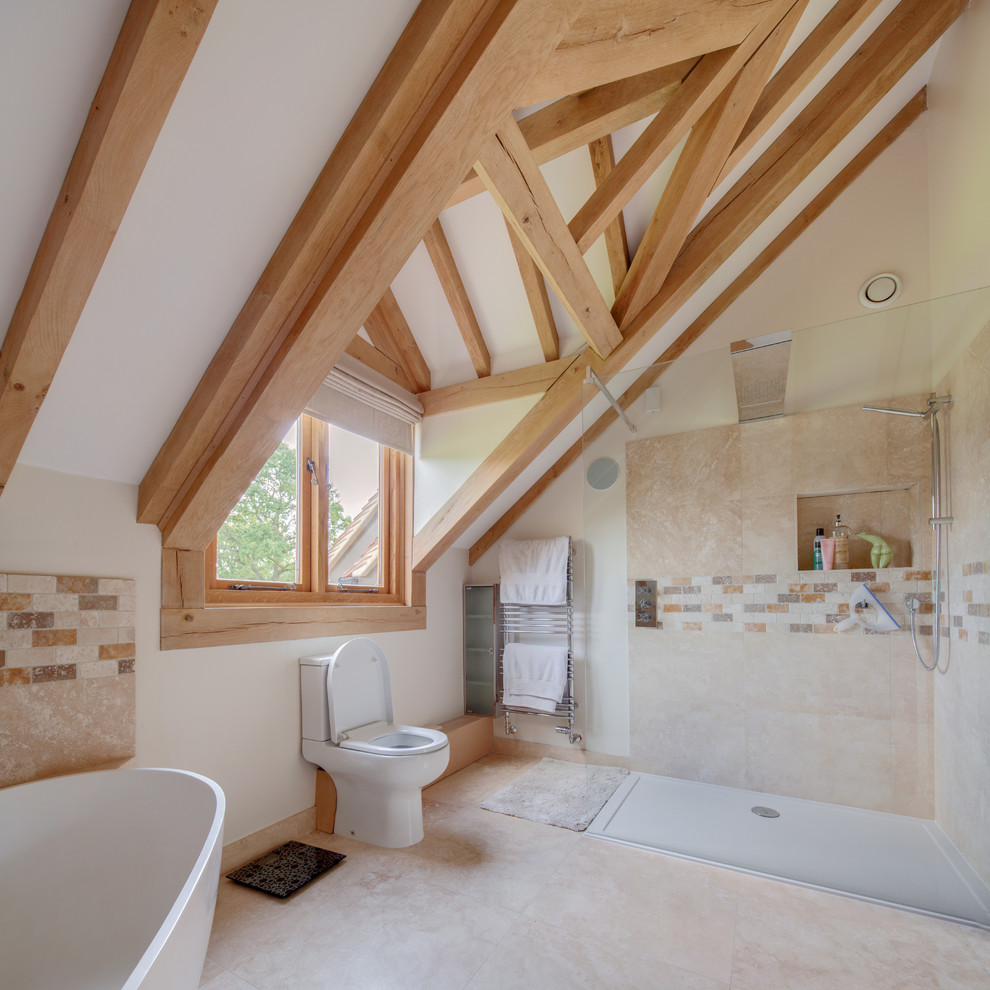 Foto på ett lantligt en-suite badrum, med ett fristående badkar, en hörndusch, en toalettstol med separat cisternkåpa, beige kakel, brun kakel, vita väggar och beiget golv