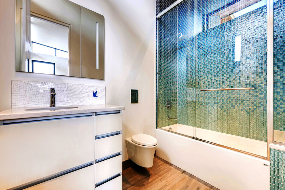 Mid-sized trendy kids' blue tile and glass tile ceramic tile and beige floor bathroom photo in Denver with flat-panel cabinets, white cabinets, a one-piece toilet, white walls, an undermount sink, quartz countertops and beige countertops