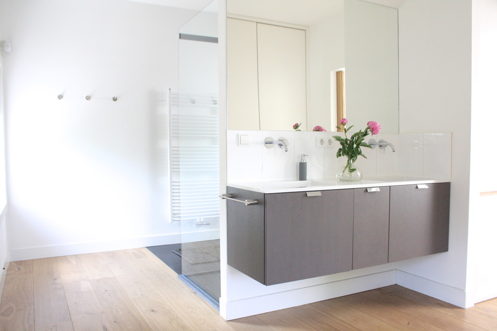 Immagine di una stanza da bagno minimal con ante lisce, ante grigie e doccia alcova