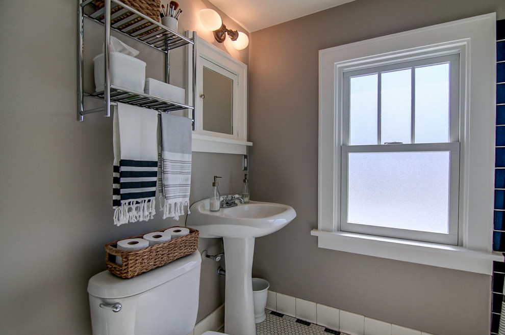 Foto di una stanza da bagno di medie dimensioni con lavabo a colonna, WC a due pezzi, piastrelle bianche, piastrelle in ceramica, pareti grigie e pavimento con piastrelle a mosaico