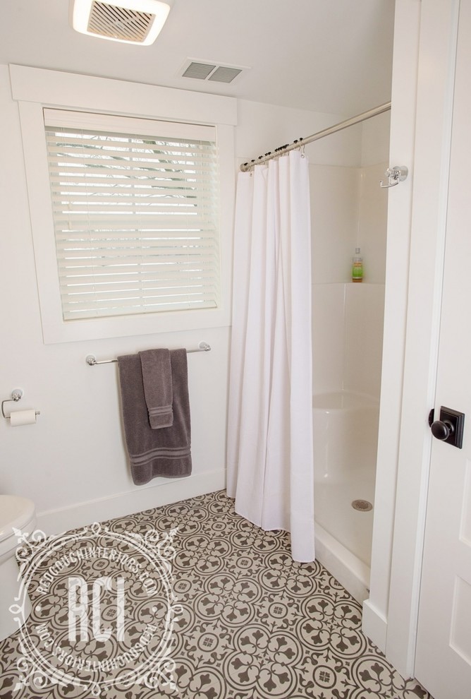 This is an example of a medium sized farmhouse shower room bathroom with shaker cabinets, brown cabinets, an alcove shower, a one-piece toilet, white walls, lino flooring, a submerged sink, engineered stone worktops, black floors and a shower curtain.