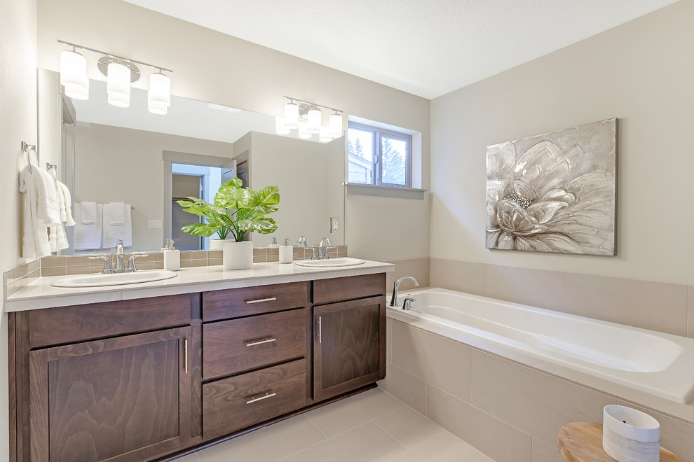 Bathroom - mid-sized modern master beige tile and ceramic tile cement tile floor and beige floor bathroom idea in Portland with shaker cabinets, medium tone wood cabinets, a two-piece toilet, beige walls, a drop-in sink, tile countertops, a hinged shower door and beige countertops