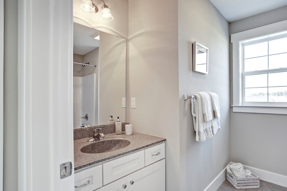 This is an example of a medium sized traditional ensuite bathroom in Other with grey cabinets, a shower/bath combination, a two-piece toilet, grey walls, ceramic flooring, an integrated sink, grey floors and a shower curtain.