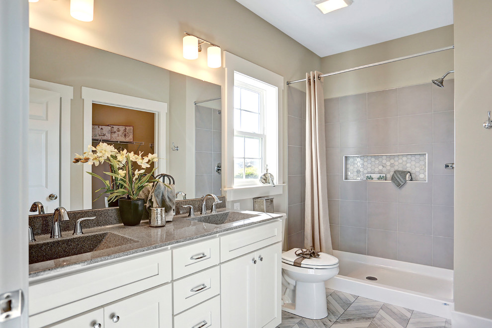 Mid-sized elegant master ceramic tile and gray floor bathroom photo in Other with a two-piece toilet, gray walls and an integrated sink