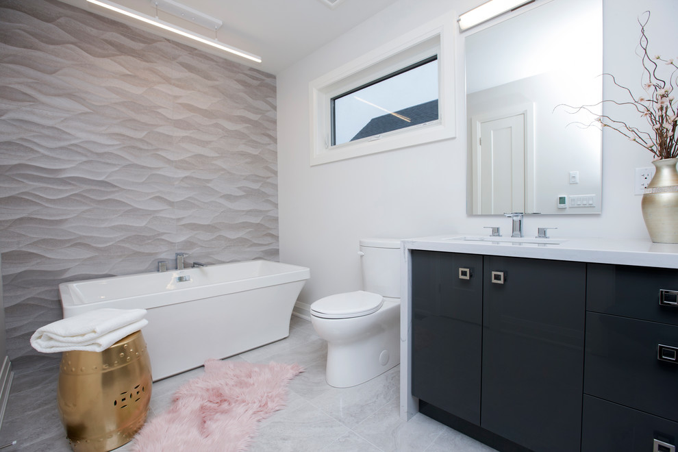 Design ideas for a medium sized classic ensuite bathroom in Other with freestanding cabinets, black cabinets, quartz worktops, white worktops, a freestanding bath, an alcove shower, a two-piece toilet, grey tiles, porcelain tiles, grey walls, a submerged sink, grey floors, a hinged door and porcelain flooring.