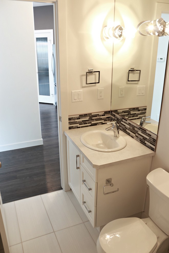 Exempel på ett mellanstort modernt badrum för barn, med ett nedsänkt handfat, luckor med infälld panel, vita skåp, laminatbänkskiva, en dusch/badkar-kombination, en toalettstol med hel cisternkåpa, grå kakel, mosaik, vita väggar och klinkergolv i keramik