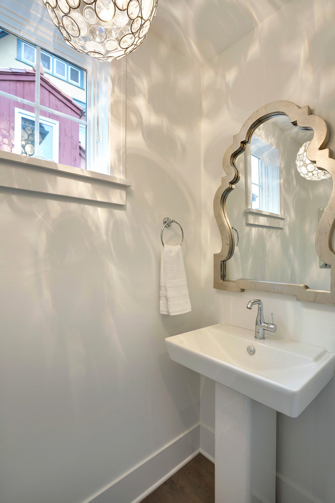 Klassisk inredning av ett litet badrum med dusch, med vita väggar, mörkt trägolv och ett piedestal handfat