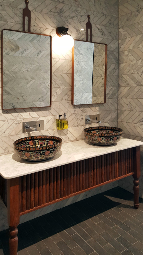 Idée de décoration pour une salle de bain principale tradition en bois brun de taille moyenne avec un placard en trompe-l'oeil, un carrelage gris, du carrelage en marbre, un mur gris, une vasque, un plan de toilette en marbre et un sol noir.