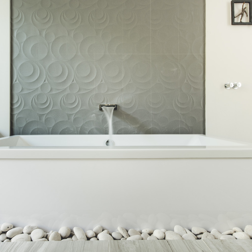 Cette photo montre une salle de bain principale moderne de taille moyenne avec une baignoire indépendante, un carrelage gris, des carreaux de béton, un mur blanc, parquet clair et un sol gris.