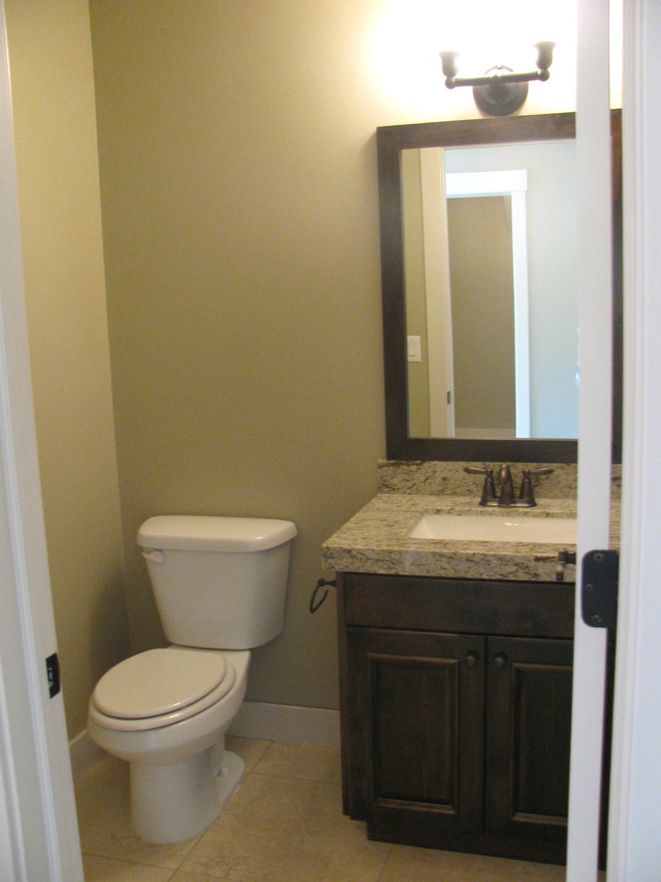 Inspiration for a large timeless 3/4 beige tile and ceramic tile ceramic tile bathroom remodel in Salt Lake City with an undermount sink, raised-panel cabinets, dark wood cabinets, granite countertops, a two-piece toilet and beige walls