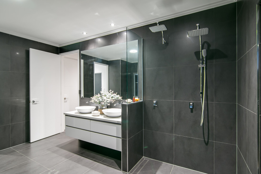 Inspiration pour une salle de bain design avec un placard à porte plane, des portes de placard blanches, une douche double, un carrelage noir, un carrelage gris et une vasque.