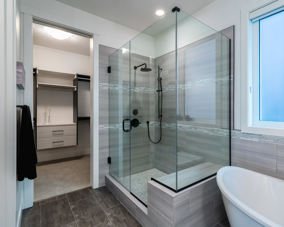 Freestanding bathtub - mid-sized contemporary master gray tile and glass tile vinyl floor and gray floor freestanding bathtub idea in Edmonton with recessed-panel cabinets, black cabinets, white walls, an undermount sink, quartzite countertops, a hinged shower door and white countertops