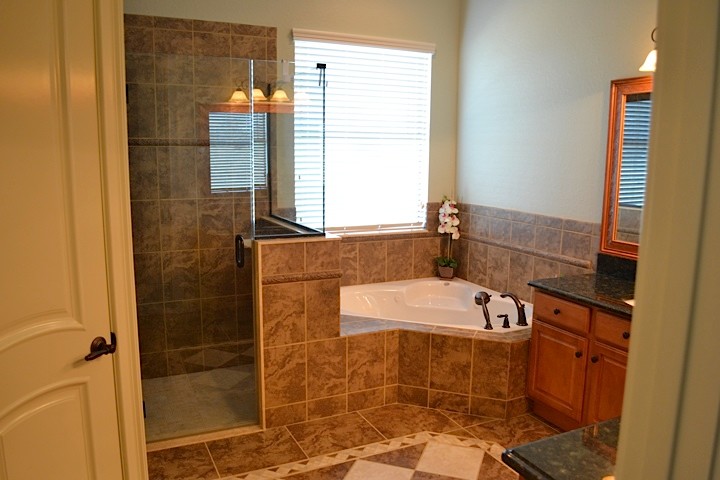 Klassisk inredning av ett mellanstort en-suite badrum, med luckor med upphöjd panel, skåp i mellenmörkt trä, ett hörnbadkar, en hörndusch, gröna väggar, klinkergolv i keramik, ett undermonterad handfat och granitbänkskiva