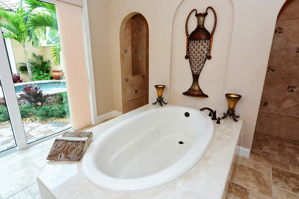 Пример оригинального дизайна: главная ванная комната в классическом стиле с гидромассажной ванной, полом из травертина, врезной раковиной и столешницей из гранита