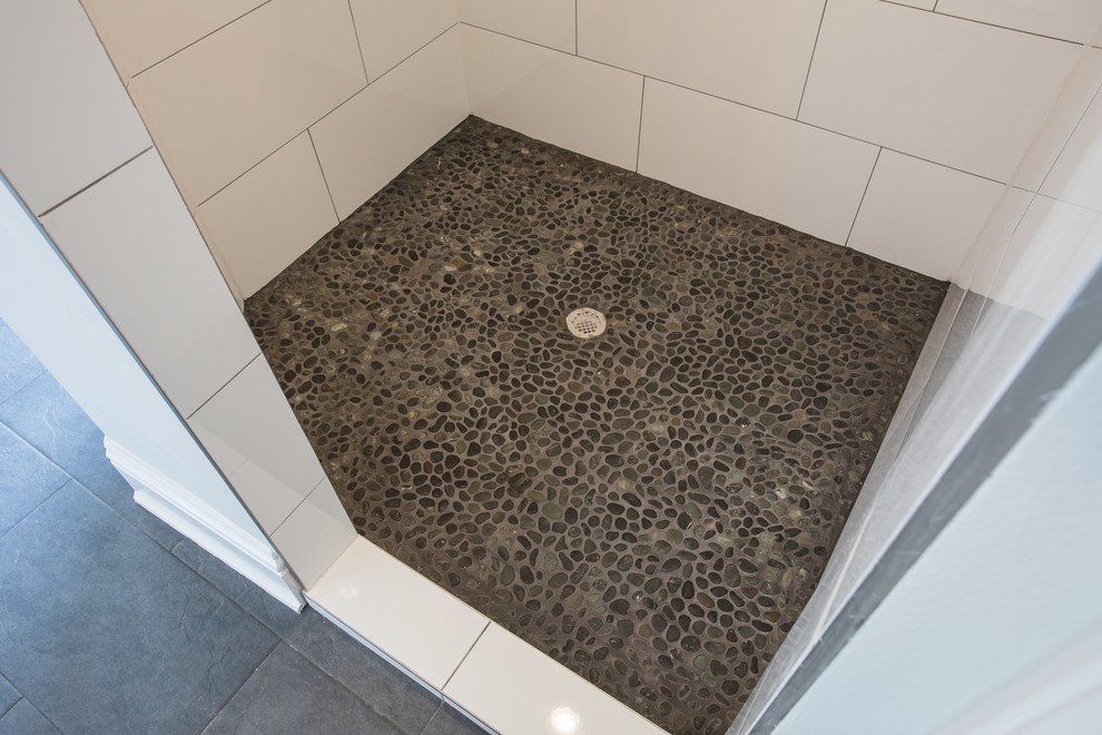 Aménagement d'une salle de bain campagne de taille moyenne avec une douche ouverte, un carrelage blanc, des carreaux de porcelaine, un mur gris et un sol en galet.