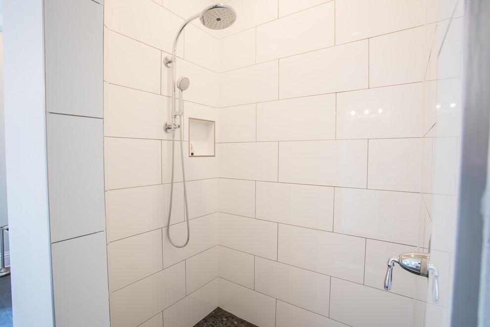 Diseño de cuarto de baño campestre de tamaño medio con ducha abierta, baldosas y/o azulejos blancos, baldosas y/o azulejos de porcelana, paredes grises y suelo de baldosas tipo guijarro