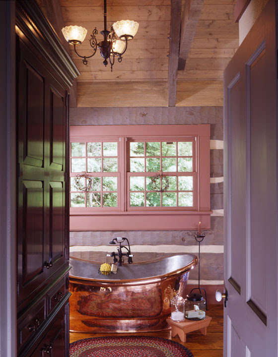 Bild på ett stort rustikt en-suite badrum, med ett fristående badkar och mörkt trägolv