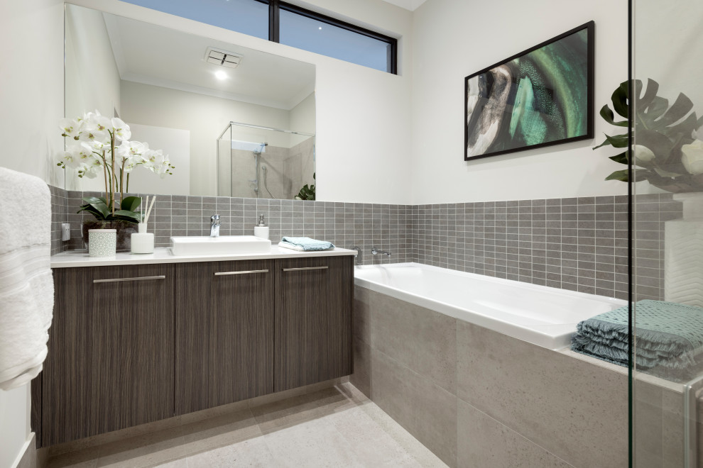 Cette photo montre une salle de bain principale tendance en bois brun avec un placard à porte plane, une baignoire posée, une douche d'angle, un carrelage gris, un mur blanc, une vasque, un sol beige, une cabine de douche à porte battante et un plan de toilette blanc.