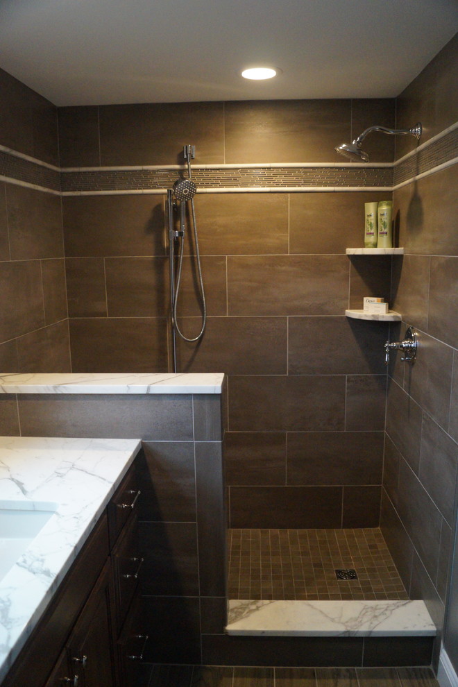 Exempel på ett litet klassiskt badrum med dusch, med luckor med upphöjd panel, skåp i mellenmörkt trä, en öppen dusch, en toalettstol med hel cisternkåpa, grå kakel, porslinskakel, grå väggar, klinkergolv i porslin, ett undermonterad handfat och marmorbänkskiva