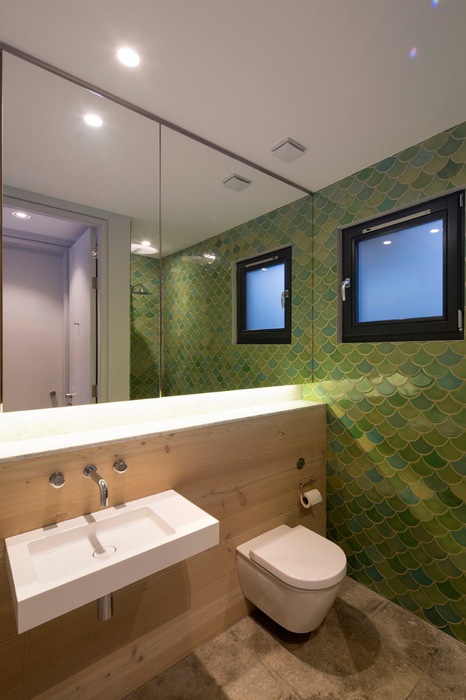 Свежая идея для дизайна: маленькая ванная комната в современном стиле с подвесной раковиной, отдельно стоящей ванной, зелеными стенами, унитазом-моноблоком, бетонным полом и зеленой плиткой для на участке и в саду - отличное фото интерьера