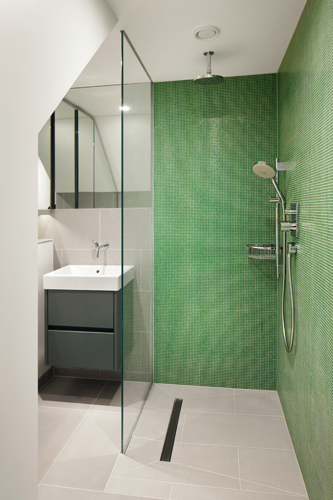 ロンドンにあるコンテンポラリースタイルのおしゃれな浴室 (壁付け型シンク、フラットパネル扉のキャビネット、グレーのキャビネット、バリアフリー、緑のタイル、モザイクタイル、緑の壁、グレーの床) の写真