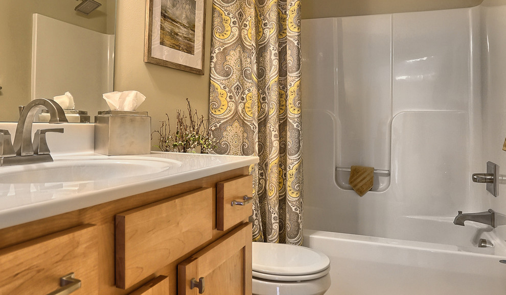 This is an example of a medium sized classic family bathroom in Other with raised-panel cabinets, light wood cabinets, a shower/bath combination, vinyl flooring, granite worktops, a one-piece toilet, beige walls and a shower curtain.