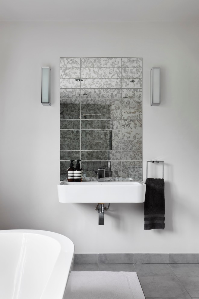 Idee per una stanza da bagno padronale minimalista di medie dimensioni con vasca freestanding, WC monopezzo, piastrelle di vetro, pareti grigie, pavimento con piastrelle in ceramica e lavabo sospeso