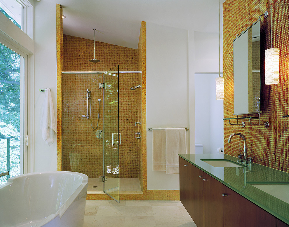 Inspiration för moderna badrum, med ett fristående badkar, bänkskiva i glas, orange kakel, mosaik och orange väggar