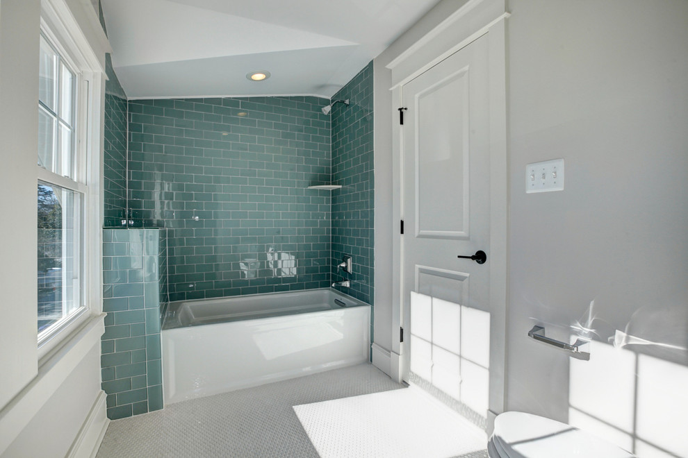 Ispirazione per una stanza da bagno american style di medie dimensioni con vasca ad alcova, vasca/doccia, WC a due pezzi, piastrelle verdi, piastrelle di vetro e pareti grigie