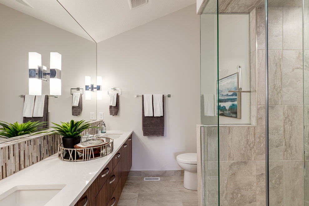 Cette photo montre une grande salle de bain principale chic en bois brun avec un placard en trompe-l'oeil, un espace douche bain, un carrelage gris, un carrelage en pâte de verre, un mur gris, un sol en marbre, un lavabo encastré et un plan de toilette en quartz modifié.
